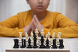 © ercan senkaya - sits at a table and plays chess. The kid concentrated on the game and thinks where to make his next move. Early development, home educational games for children