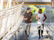 © Dollydoll - Two diverse athletes talking while jogging for exercise in the city. Friendship, diversity, exercise and health concept.