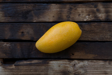 Sticker - Ripe yellow mango on dark color of wood background