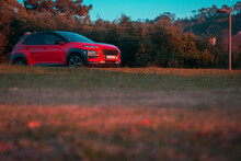 Red Car Isolated In A Sporty Setting With Sunset Tones.

