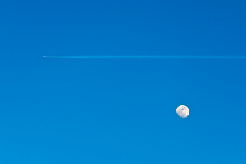Wall Mural - jet trail and full moon on blue sky
