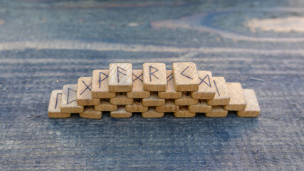 Wall Mural - Scandinavian wooden runes on an old wooden table. Elder Futhark.