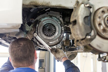 Car Repair In A Car Service. Replacing The Clutch Disc Of A Gearbox On A Car At A Service Station. Hands Of A Professional Car Mechanic. Cars Repair Technology. Technical Photography.