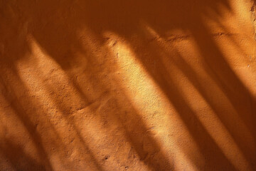 Wall Mural - Leaves Shadow on Orange Paint Concrete Wall Texture Background.