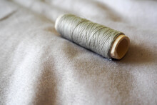 A Cardboard Skein Of Gray Silk Threads On A Gray Cotton Fabric. Hobby Sewing