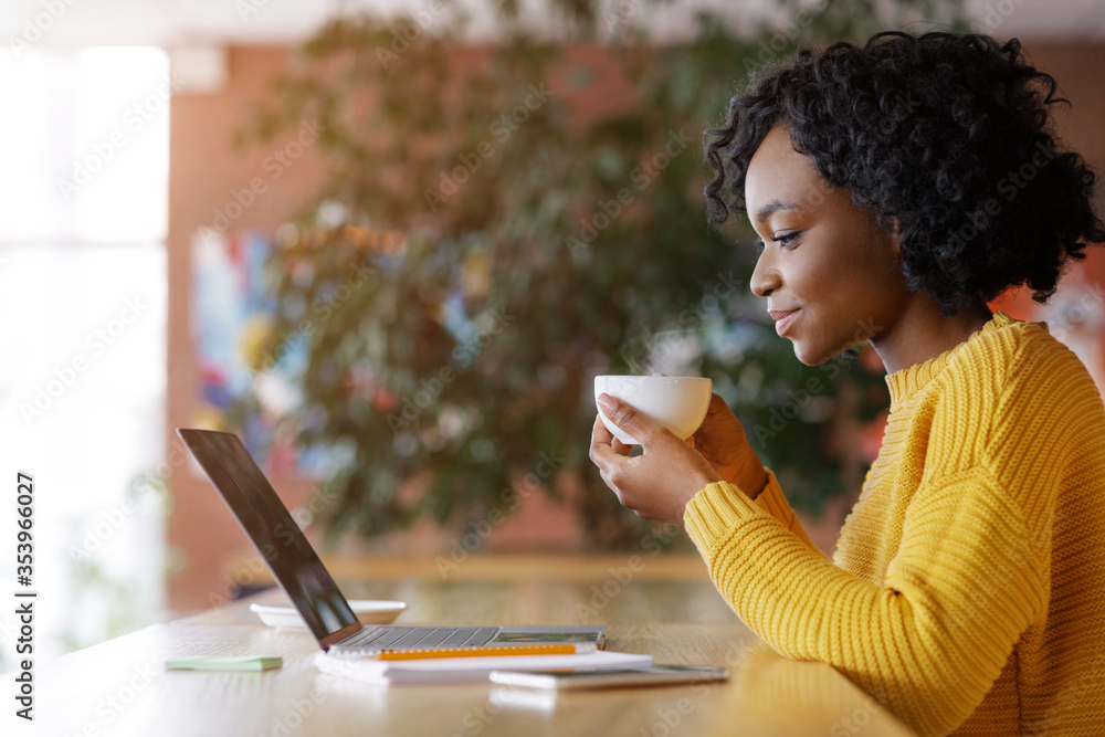 Black lady enjoying morning coffee and checking emails - obrazy, fototapety, plakaty 