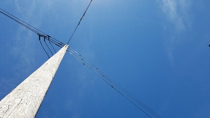 Electric post view from bottom with clear blue sky, concept of direction