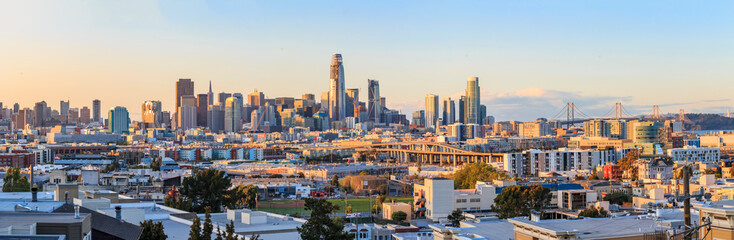 Wall Mural - San Francisco skyline panorama just before sunset with city lights, the Bay Bridge and highway leading into the city