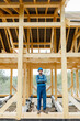© rh2010 - Builder in blue overalls and hard hat on the construction site, building wooden frame house