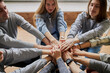© Roman - caucasian people joined their hands, they help and support each other, act like a team