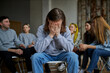 © Roman - young male suffer from alcohol addiction, cry, sit apart from group of people gathered in the club of anonymous alcoholics