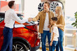 © Roman - adorable caucasian family want to rent a car for trip, they are in dealership, choosing a car.
