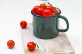 Fototapeta Kuchnia - Świeże czerwone pomidorki w zielonym kubku