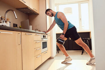 Wall Mural - Athletic young man doing exercise with electric kettle