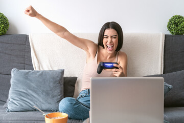 Young woman playing online video games - Happy gamer having fun on new technology console - Gaming entertainment and youth millennial generation lifestyle concept