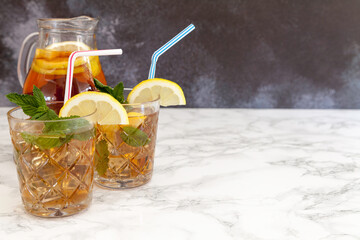 two iced tea glasses and tea jug  on dark background