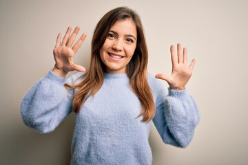 Sticker - Beautiful young woman wearing casual winter sweater standing over isolated background showing and pointing up with fingers number ten while smiling confident and happy.