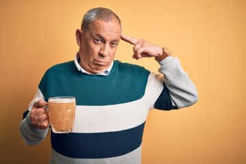 Sticker - Senior handsome man drinking jar of beer standing over isolated yellow background Shooting and killing oneself pointing hand and fingers to head like gun, suicide gesture.