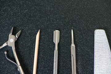 tools for manicure at home, on a black table, place for text on top