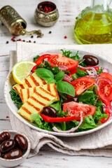 Wall Mural - Delicious salad with grilled halloumi cheese, lettuce, tomatoes, bell pepper, red onion, Kalamata olives, olive oil, Basil, lemon and spices. Mediterranean cuisine. Selective focus