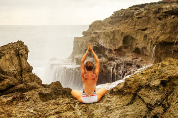 Wall Mural - Woman practices yoga at seashore