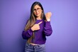 © Krakenimages.com - Young beautiful smart woman wearing glasses over purple isolated background In hurry pointing to watch time, impatience, looking at the camera with relaxed expression