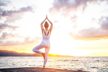 Wall Mural - Woman practices yoga at seashore