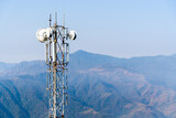 Telecommunication tower with antennas. Wireless Communication Antenna Transmitter with Mountains on Background. Stock Photo.