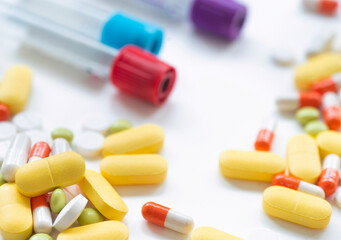 Examination of treatment control. Conducting blood test tubes on a white table with pills.