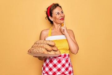 Sticker - Middle age senior housewife pin up woman wearing 50s style retro dress cooking wholemeal bread serious face thinking about question, very confused idea