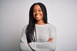 © Krakenimages.com - Young african american woman standing casual and cool over grey isolated background happy face smiling with crossed arms looking at the camera. Positive person.