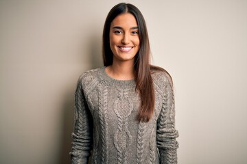 Young beautiful brunette woman wearing casual sweater over isolated white background with a happy and cool smile on face. Lucky person.