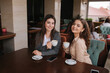 © Aleksandr - Two female friends drink coffe in restauratn and speak. Beautiful women metting in cafe. End of quarantine