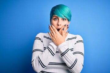 Sticker - Young beautiful woman with blue fashion hair wearing casual sweater standing at studio shocked covering mouth with hands for mistake. Secret concept.