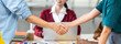 © Urbanscape - Group of Asian business people in project team brainstorm meeting, close up at young man and woman handshake together. Partner cooperation, partnership teamwork, or successful company. Banner size