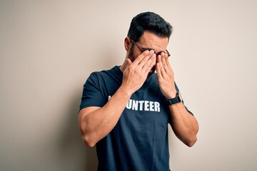 Poster - Handsome man with beard wearing t-shirt with volunteer message over white background rubbing eyes for fatigue and headache, sleepy and tired expression. Vision problem