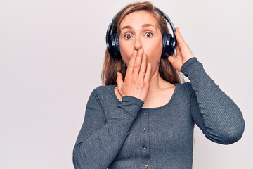 Canvas Print - Young beautiful blonde woman listening to music wearing headphones covering mouth with hand, shocked and afraid for mistake. surprised expression