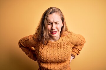 Sticker - Young beautiful blonde woman wearing casual sweater standing over yellow background Suffering of backache, touching back with hand, muscular pain