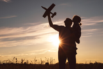 Canvas Print - Father and son playing in the park at the sunset time.