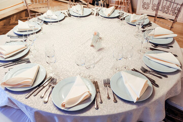 setting a round wedding table. napkins and cutlery