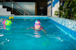 © Lena May - Happy girl in pink swimsuit with swimming hat and glasses in the blue pool in sportclub