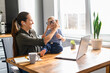 © Vadim Pastuh - Mother works from home. Mom sits in the kitchen with laptop, kid is putting her eyeglasses on.