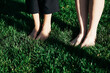 © musicStyle - bare feet of young girls stand barefoot in the dense green grass