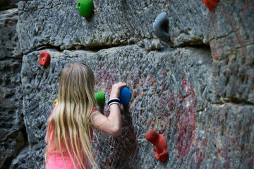 Wall Mural - Child Girl having fun during rock climbing training on boulder wall