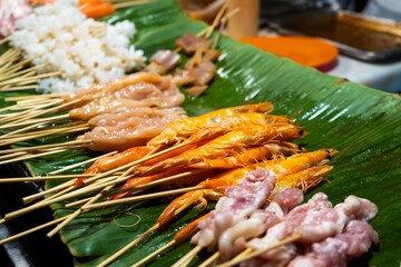 Wall Mural - Night market of food in asia. Skewers of meat, fish and shrimp.