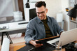 © JustLife - Young businessman using laptop in his office.  Handsome man working in office.