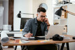 © JustLife - Businessman in office. Handsome man talking on phone at work.