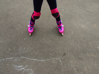 children's feet on rollers in equipment on the background of asphalt