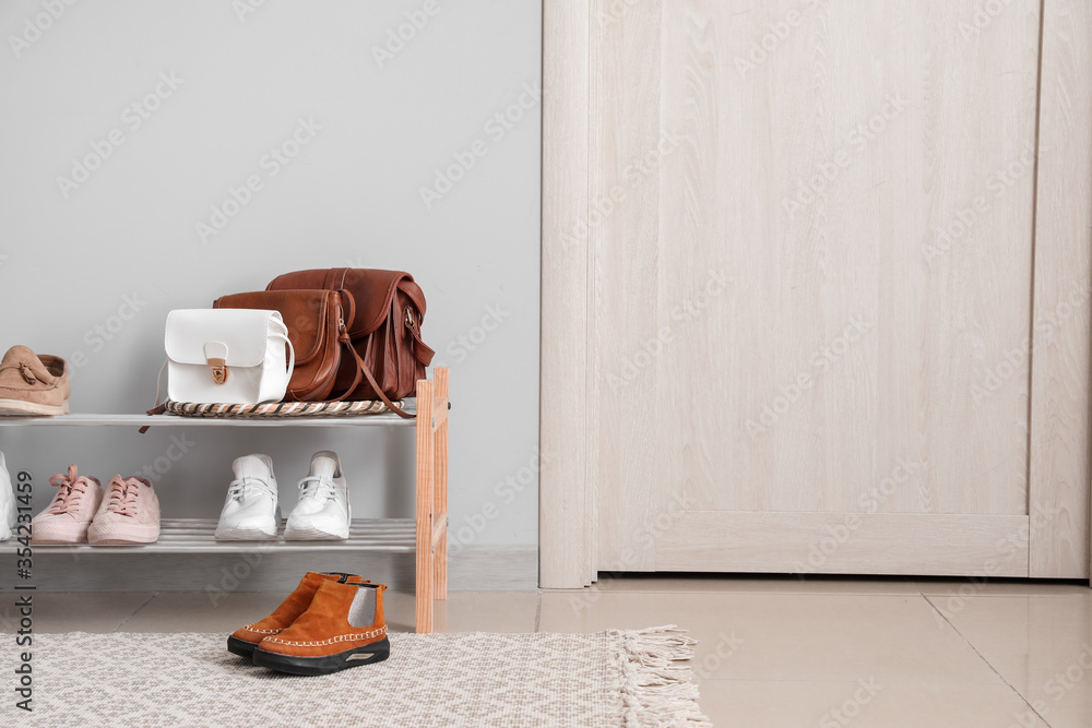 Stylish interior of modern hall with shoes on stand