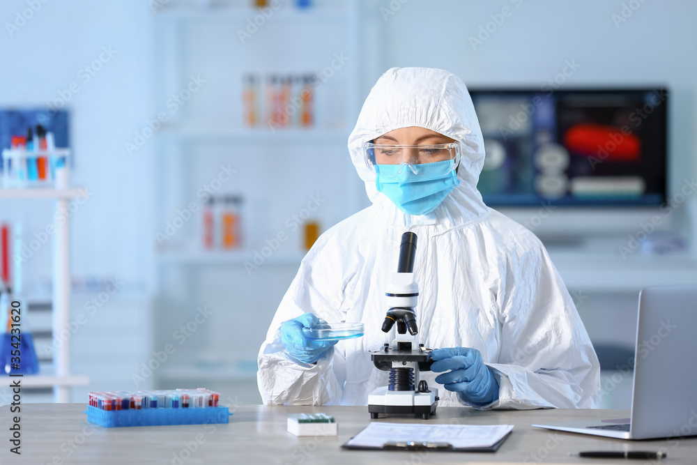 Scientist working with microscope in laboratory